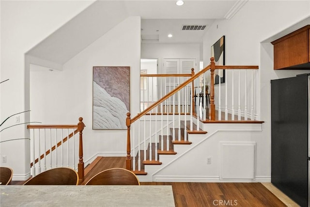 staircase with recessed lighting, wood finished floors, visible vents, and baseboards