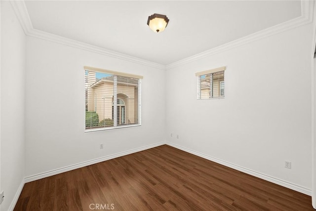 spare room with dark wood finished floors, a healthy amount of sunlight, and baseboards