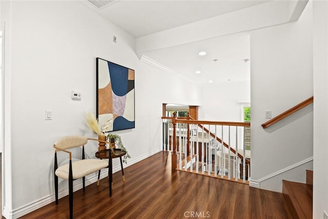 corridor with visible vents, baseboards, recessed lighting, an upstairs landing, and wood finished floors