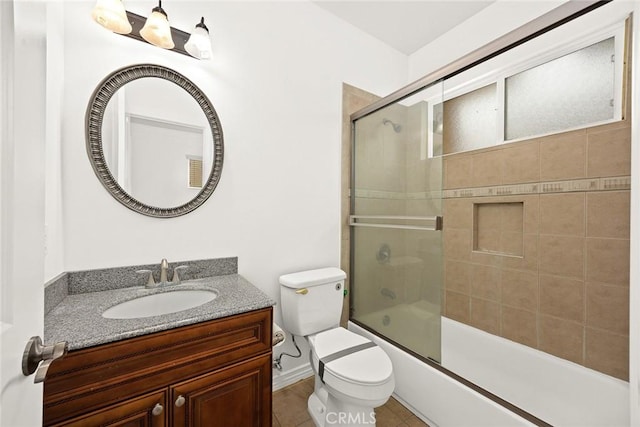 bathroom with vanity, bath / shower combo with glass door, and toilet