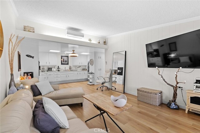 living room with a wall unit AC, ornamental molding, and light hardwood / wood-style flooring