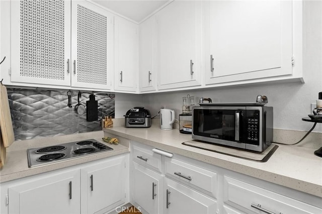 kitchen featuring stovetop and white cabinetry