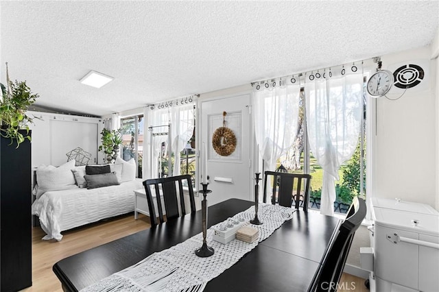 dining room with a textured ceiling and wood-type flooring