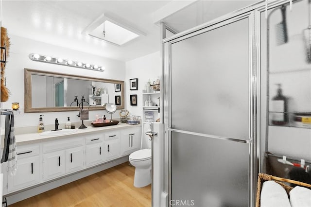 bathroom featuring toilet, a shower with door, vanity, and wood-type flooring