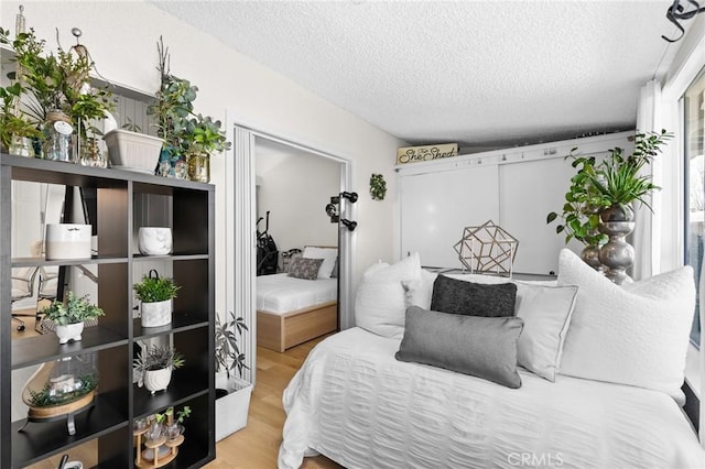 bedroom with hardwood / wood-style flooring and a textured ceiling