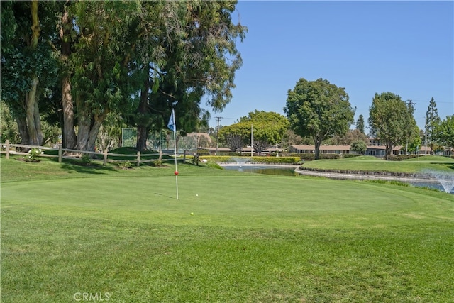 view of home's community with a water view and a lawn