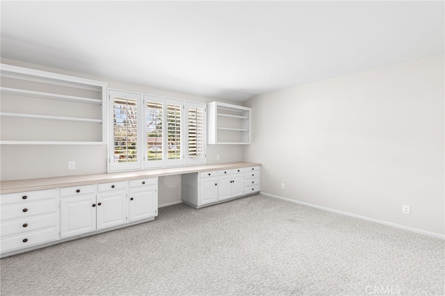 unfurnished office featuring light carpet and built in desk