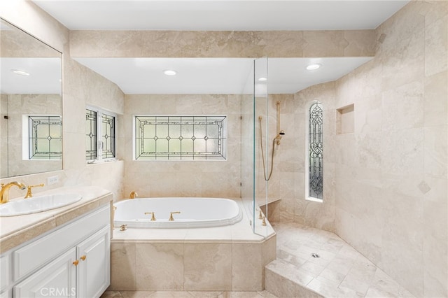 bathroom featuring tile walls, vanity, and shower with separate bathtub