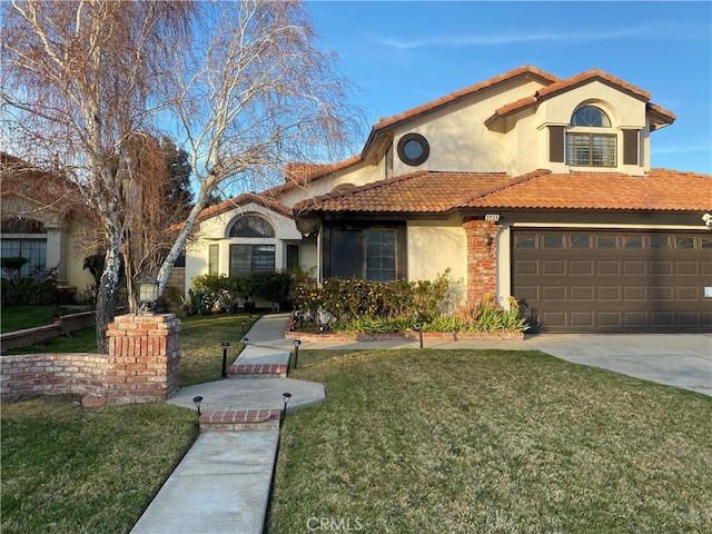 mediterranean / spanish house featuring a garage, driveway, a tiled roof, stucco siding, and a front lawn