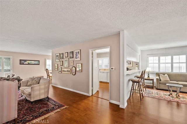 living room featuring a wealth of natural light, dark hardwood / wood-style floors, and a textured ceiling