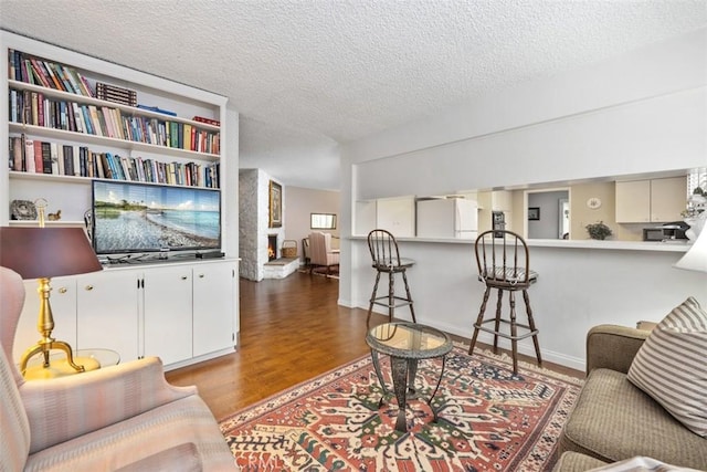 living room featuring wood-type flooring and a textured ceiling