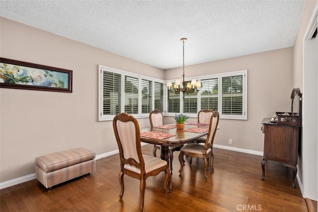 dining room with dark wood-type flooring, an inviting chandelier, and a textured ceiling