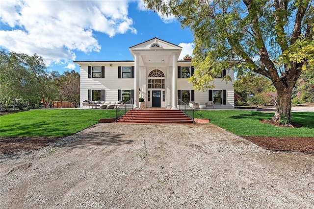 greek revival inspired property with a front lawn