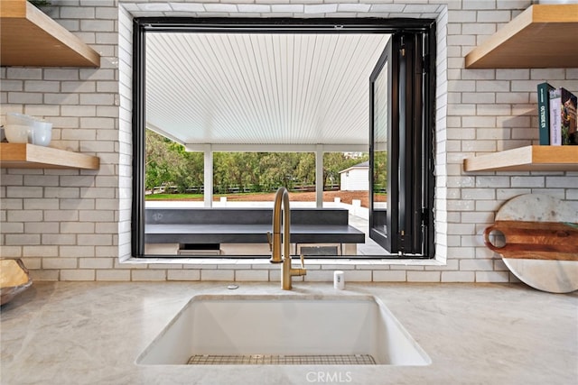 interior details with open shelves, light countertops, and a sink