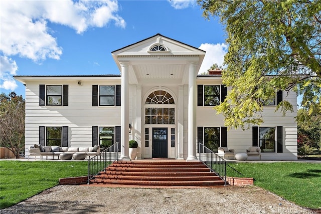 greek revival inspired property featuring an outdoor hangout area and a front lawn