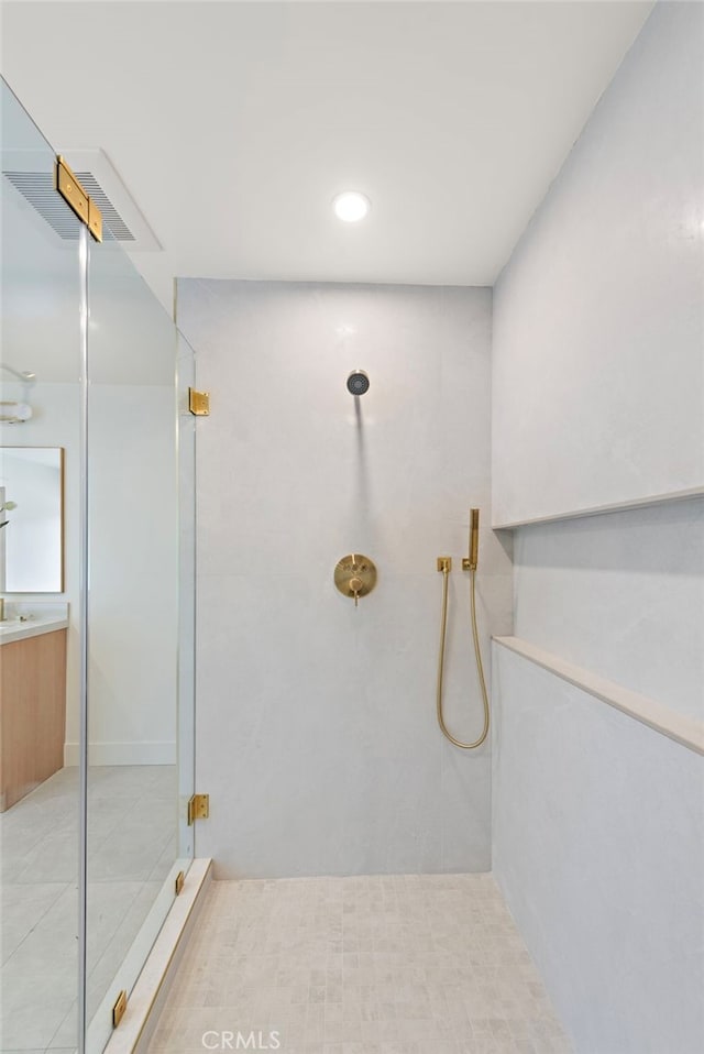 bathroom featuring tile patterned flooring, a stall shower, and vanity