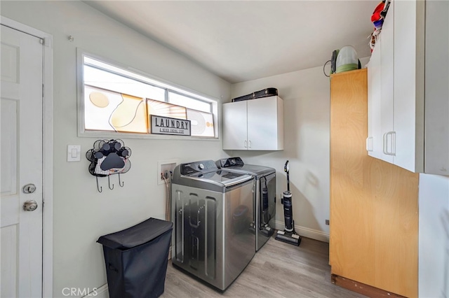 laundry room with cabinets, separate washer and dryer, and light hardwood / wood-style floors