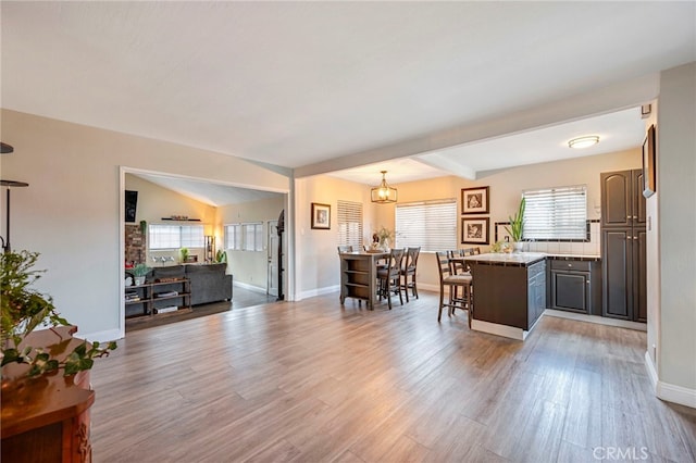 kitchen featuring a kitchen island, a healthy amount of sunlight, hardwood / wood-style floors, and a kitchen bar