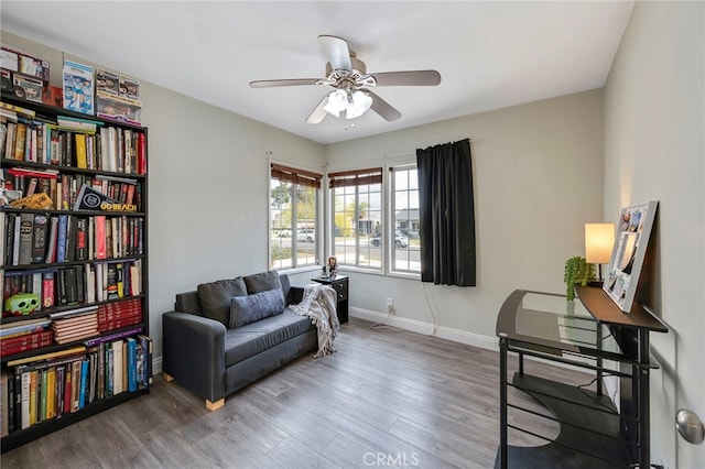 sitting room with ceiling fan and wood-type flooring