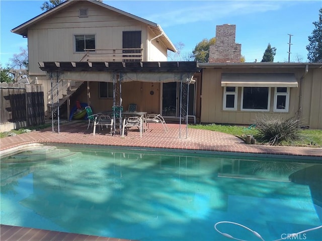 rear view of property with a fenced in pool and a patio