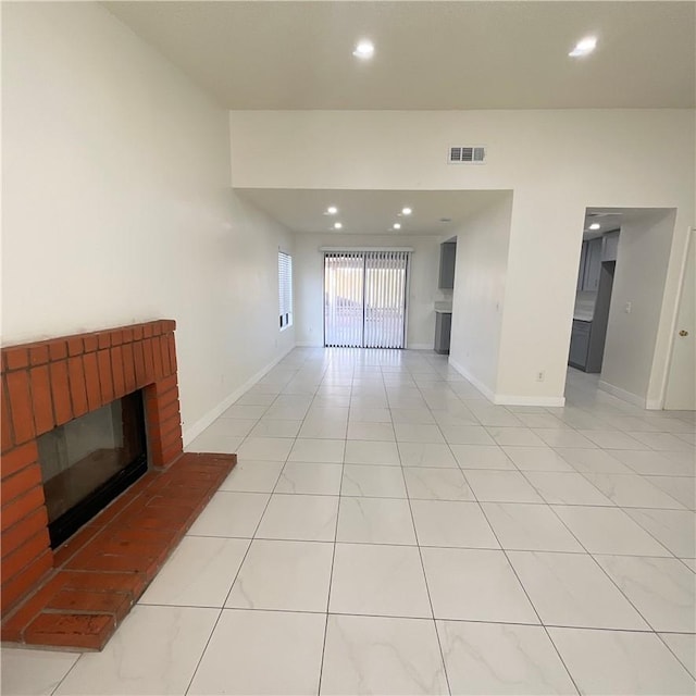 living room featuring baseboards, a fireplace, visible vents, and recessed lighting