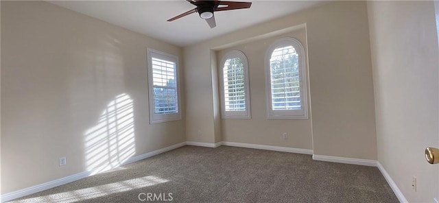 empty room with carpet, ceiling fan, and baseboards