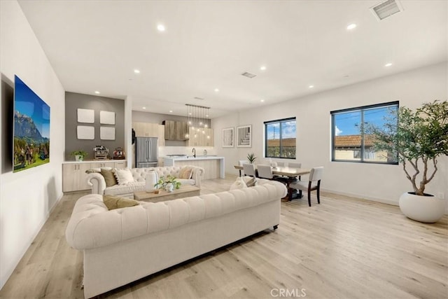 living room with sink and light hardwood / wood-style flooring