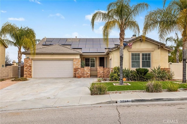 single story home with a garage and solar panels