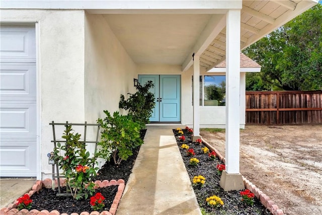 property entrance featuring fence and stucco siding