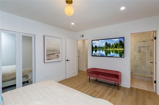 bedroom featuring ensuite bathroom, light hardwood / wood-style floors, and a closet