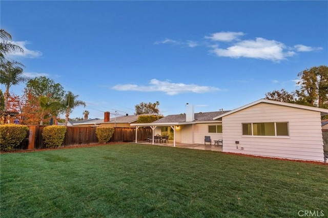 back of house with a patio area and a lawn