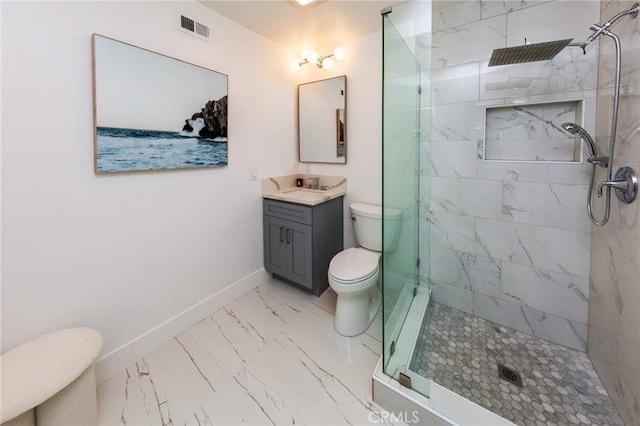 bathroom with vanity, toilet, and tiled shower