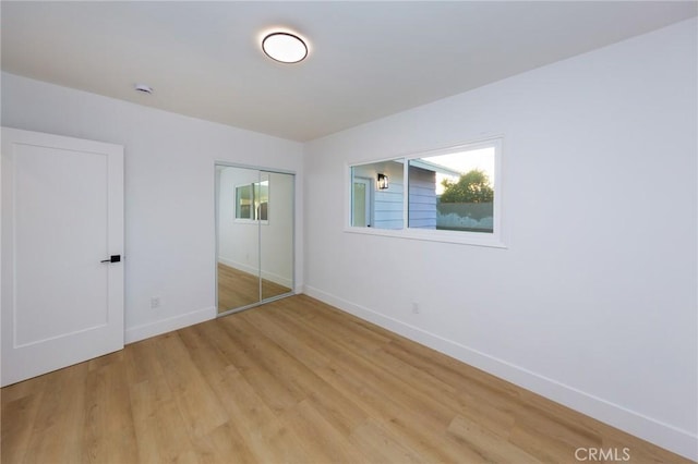 unfurnished bedroom featuring a closet and light hardwood / wood-style flooring