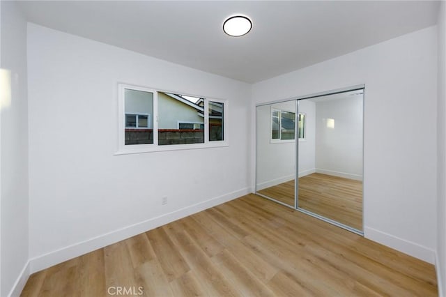 unfurnished bedroom featuring hardwood / wood-style flooring and a closet