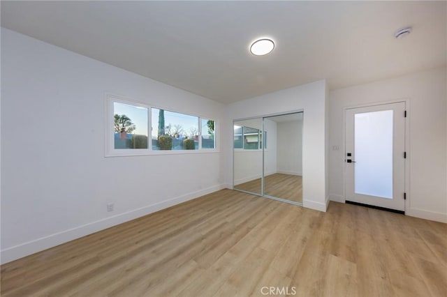 unfurnished bedroom with a closet and light wood-type flooring