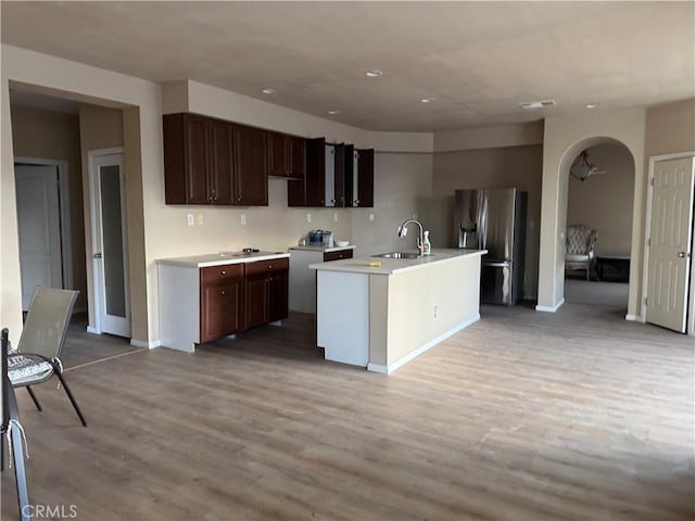 594 Hyacinth Rd, San Jacinto, CA 92582 - kitchen with sink, light hardwood / wood-style flooring, stainless steel fridge, dark brown cabinetry, and a center island with sink