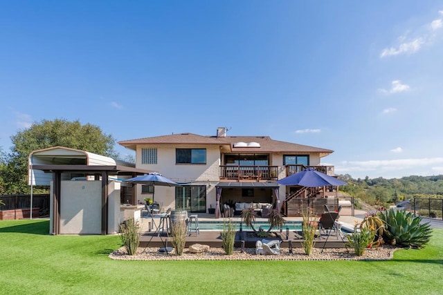 back of house featuring a balcony, a yard, a fenced in pool, a chimney, and a patio area