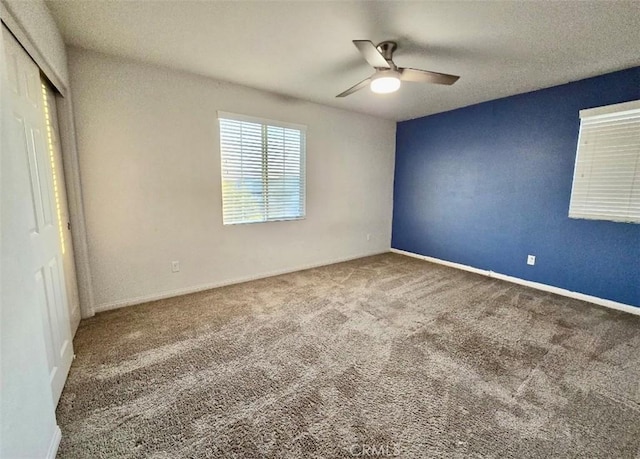 unfurnished bedroom featuring ceiling fan, carpet flooring, and a closet