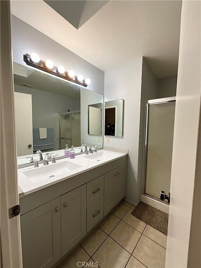 bathroom with vanity, a shower with door, and tile patterned flooring