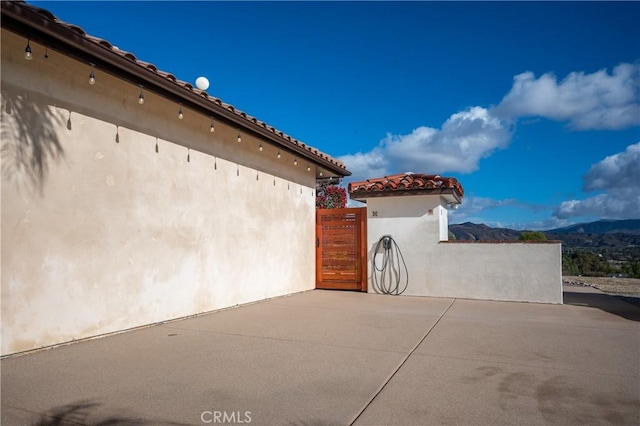 view of side of home featuring a mountain view and a patio