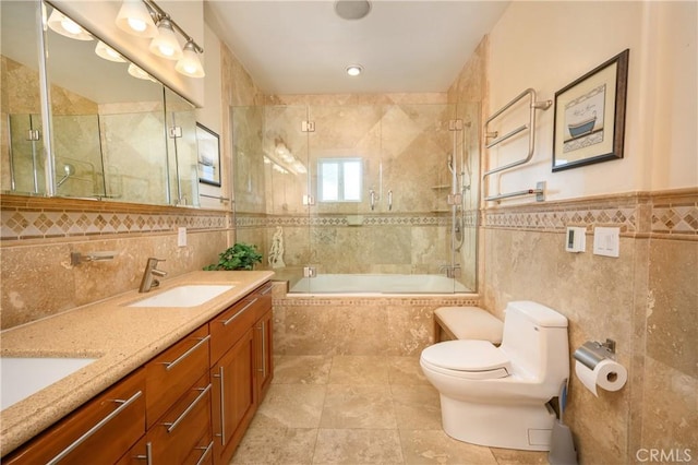 full bathroom with tile walls, vanity, toilet, and combined bath / shower with glass door