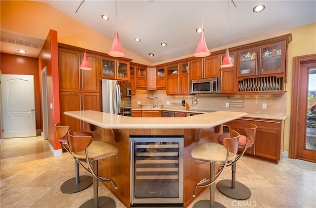 kitchen featuring stainless steel appliances, wine cooler, a kitchen breakfast bar, and decorative light fixtures