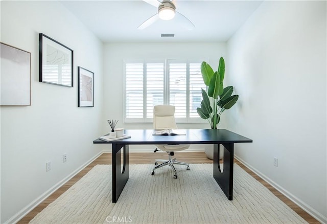 home office with ceiling fan and light hardwood / wood-style flooring