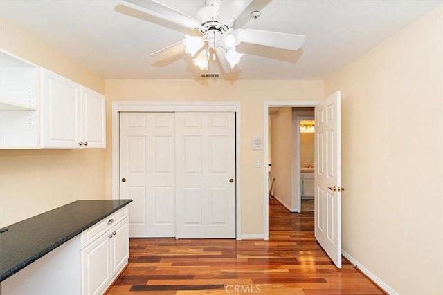 interior space with a closet, dark hardwood / wood-style floors, and ceiling fan