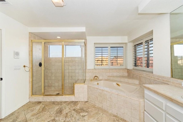 bathroom featuring independent shower and bath, vanity, and a healthy amount of sunlight