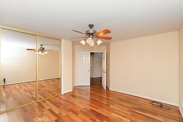 unfurnished bedroom with hardwood / wood-style flooring, ceiling fan, and a closet