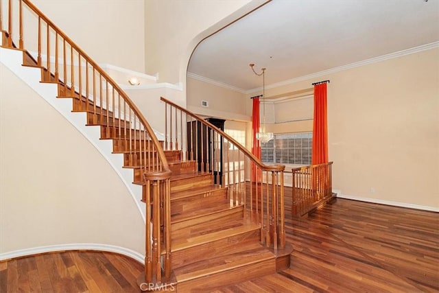 stairs with hardwood / wood-style flooring and ornamental molding