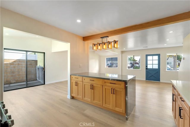 kitchen with beamed ceiling, light hardwood / wood-style floors, pendant lighting, and light brown cabinets