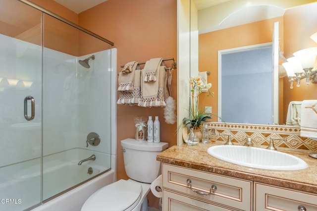 full bathroom with vanity, bath / shower combo with glass door, backsplash, and toilet