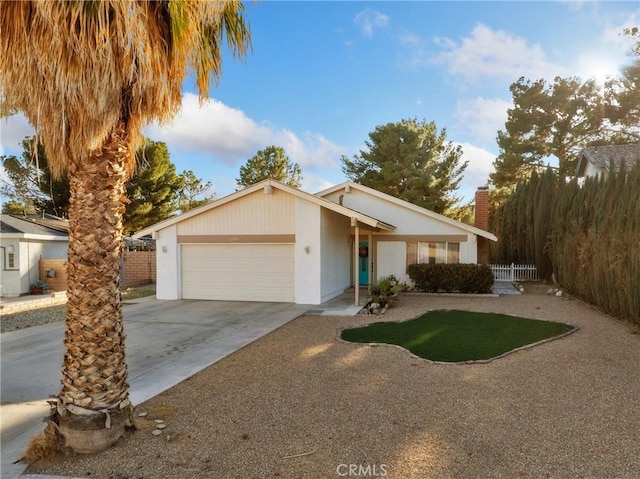 27767 Hummingbird Ln, Helendale, CA 92342 - view of front facade with a garage, driveway, a chimney, and stucco siding